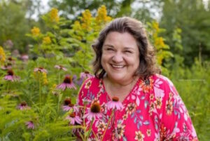 Andrea is smiling in a garden